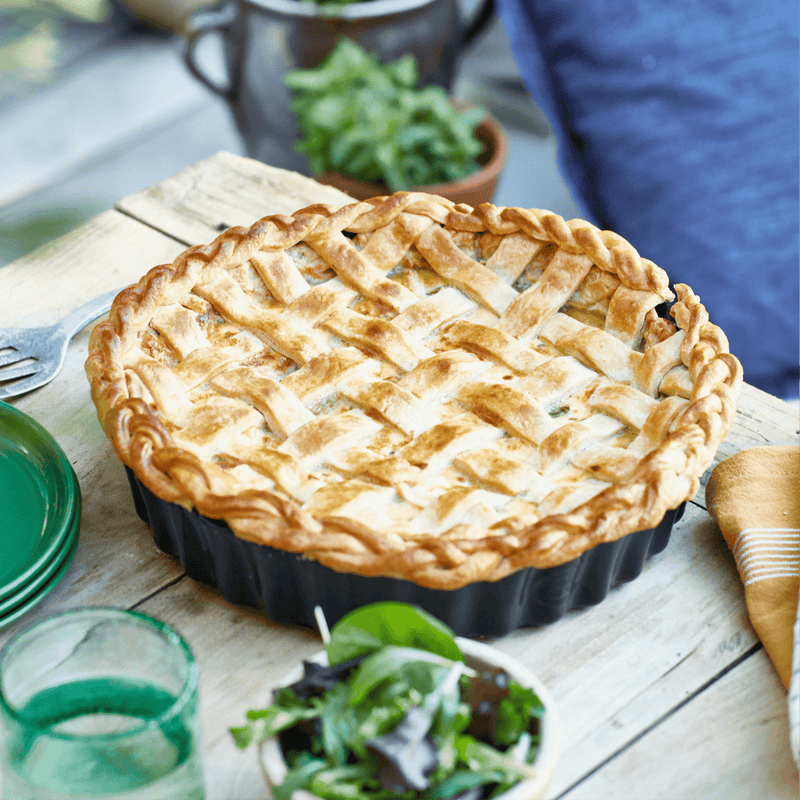Emile Henry Deep Flan & Tart Dish, 2.1QT, showcased with a freshly baked lattice-top pie, highlighting its rustic charm on a weathered wooden tabletop.