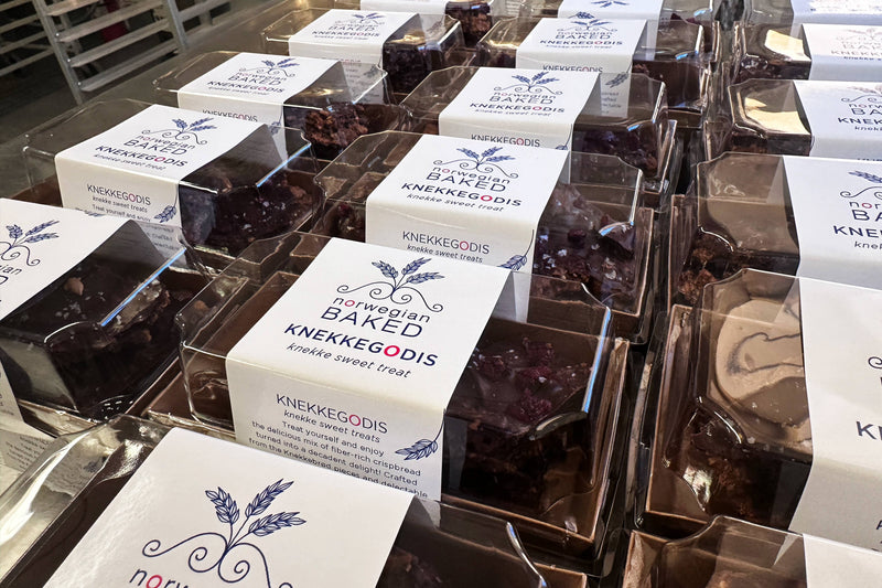 Norwegian Baked - KnekkeGodis in plastic containers, a Nordic cookie toffee bark with dark chocolate, caramel, cranberries, and Maldon sea salt flakes.