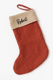 MagicLinen - Embroidered Christmas Stocking in rust-red with Robert embroidered on beige cuff, made from soft linen, featuring a hanging loop, part of zero-waste initiative.