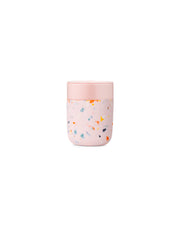 Reusable Ceramic Mug: Terrazzo Blush, 16 oz with splash-resistant lid and silicone sleeve, offering a stylish, eco-friendly alternative to disposable coffee cups.