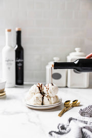 Kosterina - Dark Chocolate Balsamic Vinegar (375ml) being poured over ice cream, enhancing the dessert with its rich, velvety texture and intense aromatic notes.