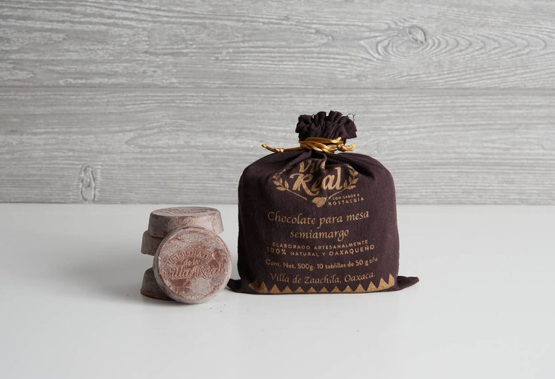 Verve Culture - Villa Real Mexican Hot Chocolate: Vanilla / Small - 5 Discs in a dark pouch with gold lettering, next to three chocolate discs.