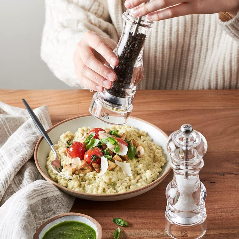 Peugeot | Paris Nancy Salt Mill, 9 Inches, showcased with a creamy risotto, highlighting its transparent design and adjustable coarseness feature, enhancing the kitchen experience.
