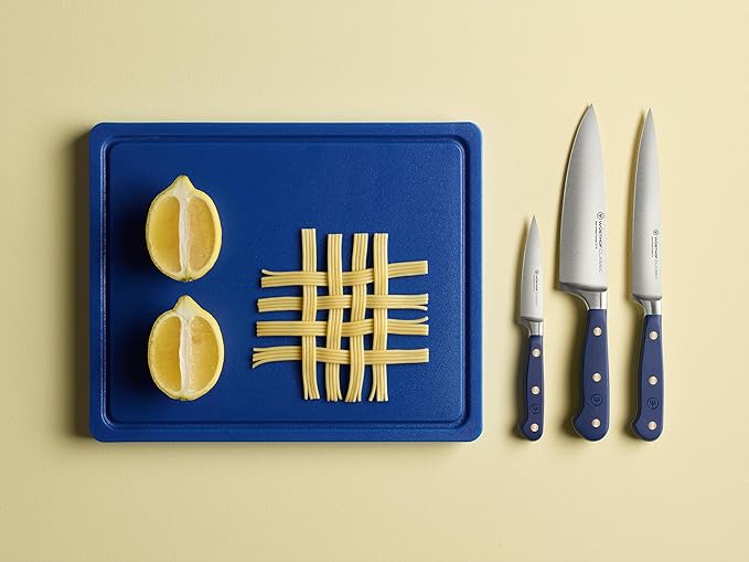 Wüsthof Classic 6 Utility Knife Wild Blueberry displayed on a cutting board with sliced lemons, showcasing its precision and versatility for kitchen tasks.