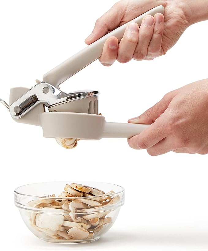 Chef'n FreshForce Handheld Slicer in use, slicing mushrooms effortlessly. A person demonstrates its ease and safety in a kitchen setting.