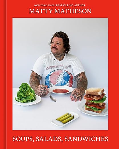 Cover of Matty Matheson: Soups, Salads, Sandwiches: A Cookbook featuring author with soup, lettuce, pickles, and sandwich at a white table.