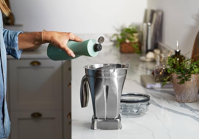 Vitamix | 48 oz Stainless Steel Container being filled, suitable for full-size blenders, designed for durability and easy cleaning, ideal for mess-free blending.