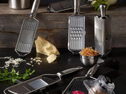 Rösle | Coarse Grater with Wire Handle, featuring sharp edges for grating vegetables, cheese, and chocolate, includes a food grip hand guard for safe use.