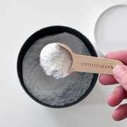 Common Good - Dishwasher Powder spooned into a bowl, highlighting its powder form and effectiveness for grease-free, sparkling dishes. Available at Athens Cooks.