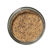 San Juan Island Sea Salt - Burger and Steak Seasoning Blend in a glass jar, showcasing a light brown coarse powder with darker flecks.