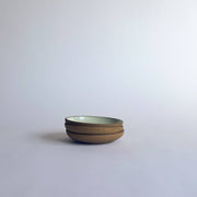 Sarah Kersten - Olive Dish: Basin Collection: Black, a versatile, small ceramic dish ideal for serving olives or bread, featured in a stack on a white surface.