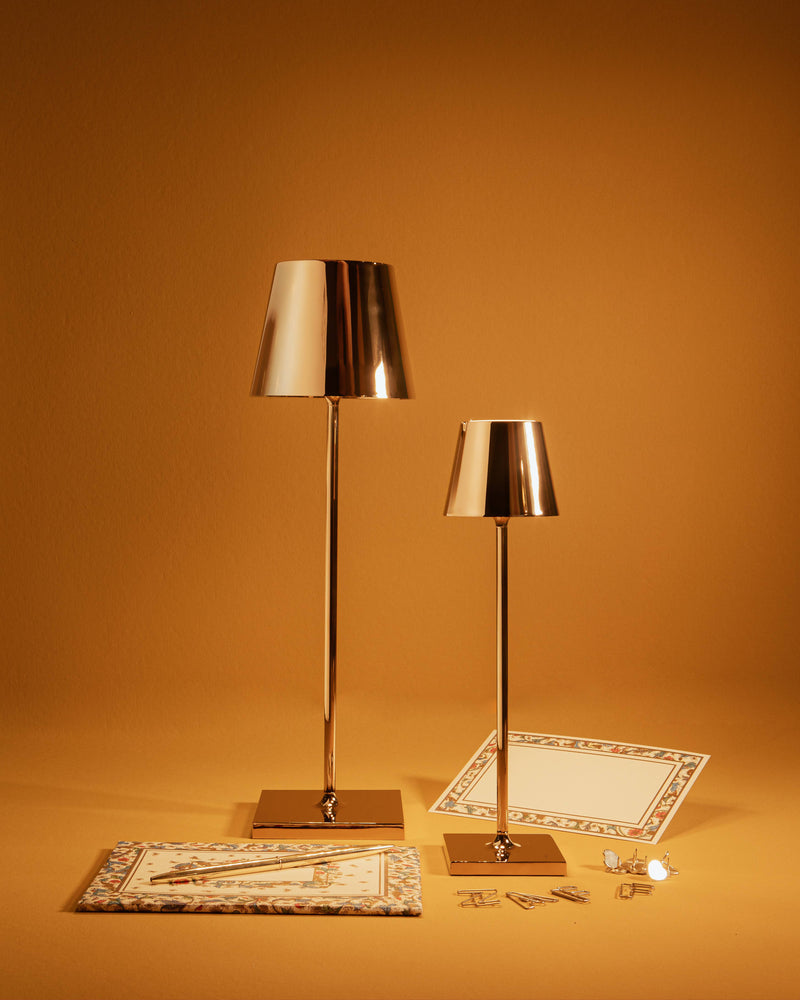 Zafferano America - Poldina Pro Micro Cordless Lamp: White, shown on a table with a sleek, touch-dimmable design and a shiny silver lampshade.