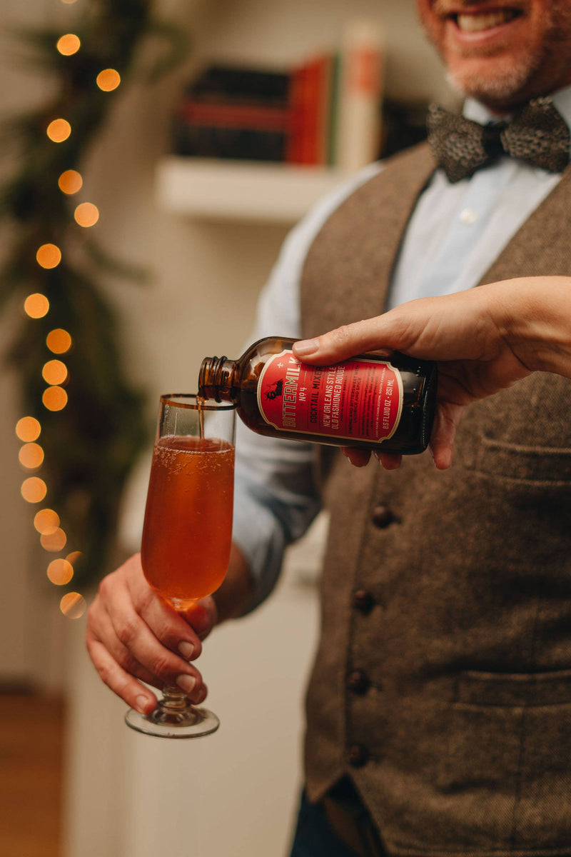 Bittermilk Bottling Co. - Bittermilk No.4 - New Orleans Style Old Fashioned Rouge being poured into a glass, highlighting its use as a cocktail mixer.