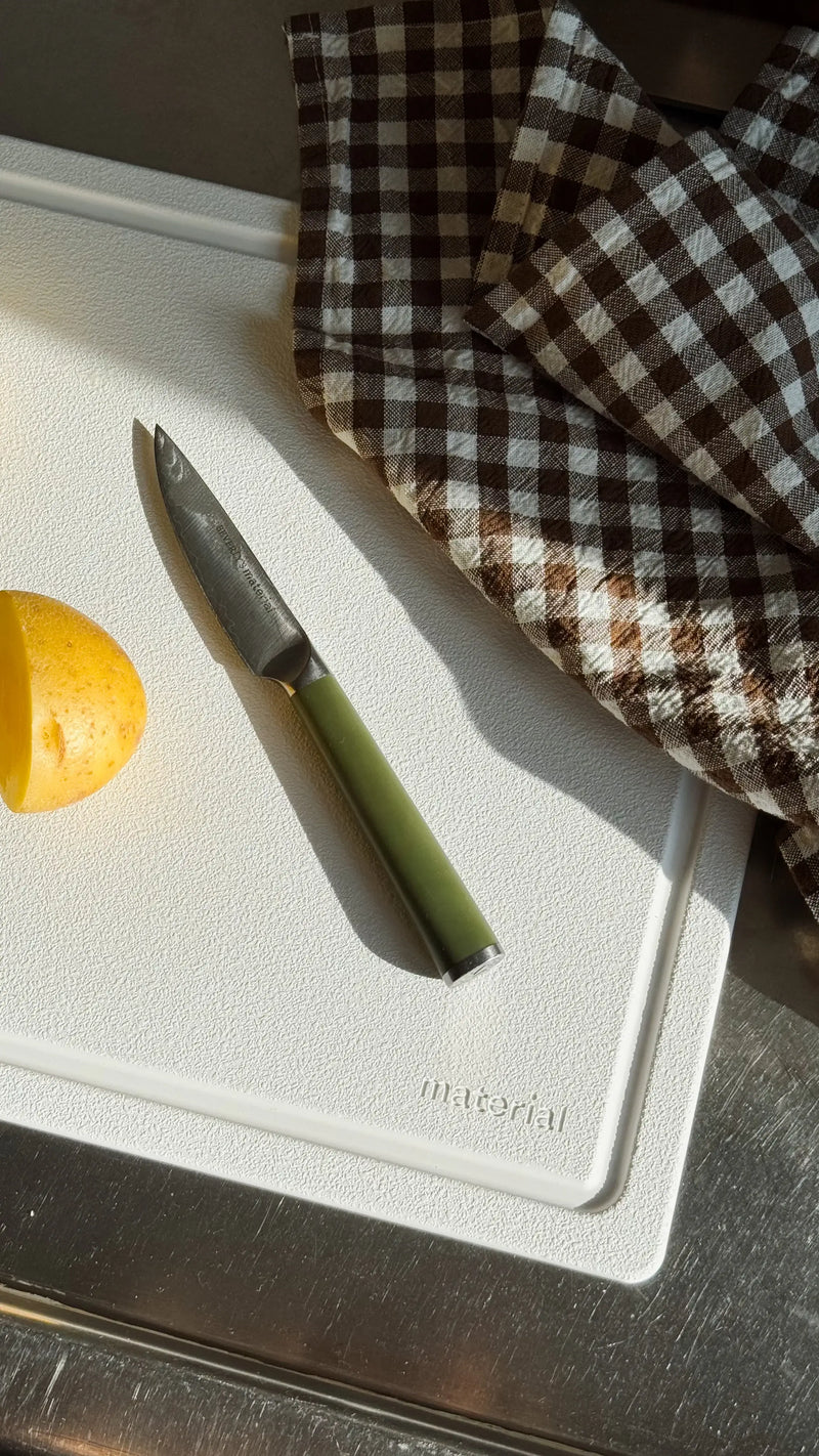Material - The MK Free Board: Ocean, featuring a paring knife and peeled potato, embodies innovative, plant-based design for efficient, eco-friendly kitchen prep.