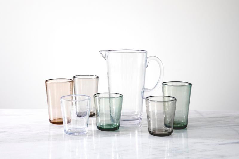 Fortessa Veranda HiBall 19oz Sky Blue Tumbler on a table with other clear glasses, showcasing elegant drinkware for refined dining.