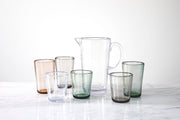 Zwiesel Fortessa Veranda HiBall Clear Tumbler, 19oz, Brown, nestled among six tinted tumblers, on a marble surface, showcasing rustic, durable polycarbonate design.