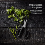 Shun | Shear Set, 2-Piece: Overhead view of parsley and black-handled kitchen shears showcasing their sharp, durable Japanese 420J2 stainless steel blades on charred wood surface.