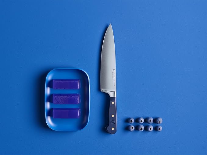 Wüsthof | Classic 8 Chef's Knife Wild Blueberry, shown with blueberries on a blue surface, highlighting its precision blade, perfect for culinary tasks.