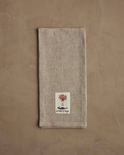 Coral & Tusk - Deck the Halls Bear Tea Towel with embroidered holiday bear design, featuring a sewn label with red coral and whale tusk motif.