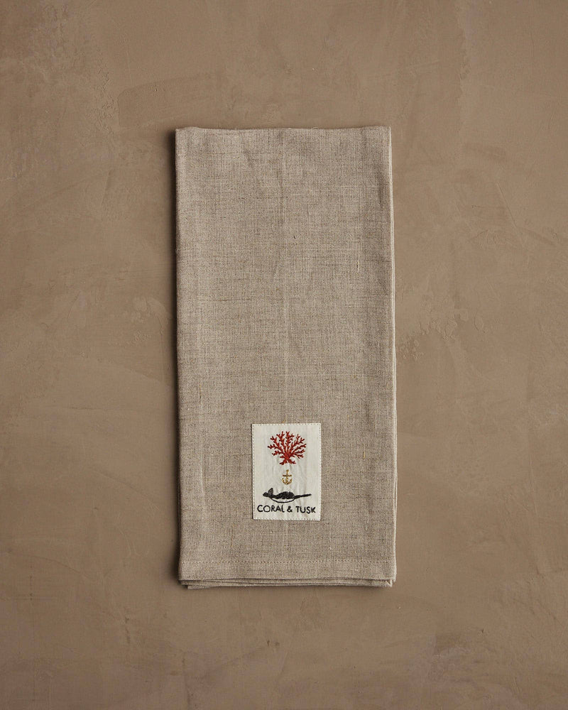 Coral & Tusk - Deck the Halls Bear Tea Towel with embroidered holiday bear design, featuring a sewn label with red coral and whale tusk motif.
