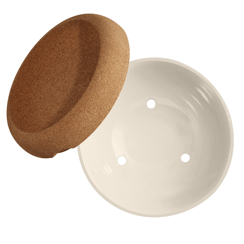 Emile Henry | Deep Storage Bowl with a ceramic pot featuring drainage holes and a cork saucer, designed for optimal produce storage.