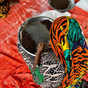 Person sorting beans on a tray, illustrating the sourcing process of Burlap & Barrel - Curry - Single Origin Spice Blend: 1.8 oz glass jar from Zanzibar farmers.