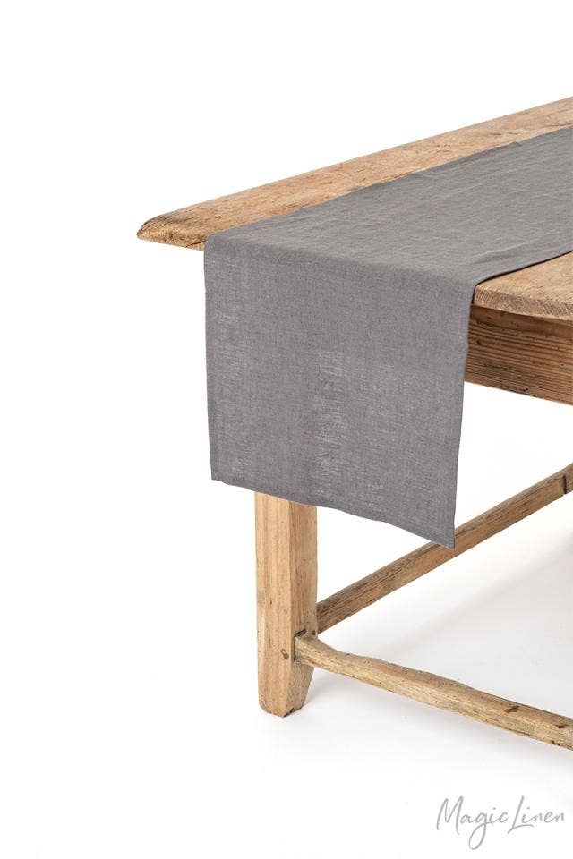 MagicLinen - Linen table runner on a wooden table, soft and easy to care for, available in various sizes and colors for versatile dining decor.