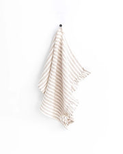 MagicLinen ruffle trim tea towel hangs on a hook, showcasing its soft, absorbent linen texture, ideal for stylish and functional kitchen use.