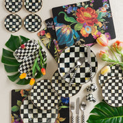 MacKenzie-Childs | Courtly Check Butter Box on a spring-themed table with coordinated checkerboard dinnerware, floral placemats, tulips, and tropical leaves, highlighting its elegant design.