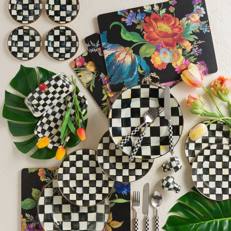 MacKenzie-Childs | Courtly Check Butter Box on a spring-themed table with coordinated checkerboard dinnerware, floral placemats, tulips, and tropical leaves, highlighting its elegant design.