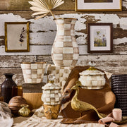 MacKenzie Childs | Mocha Check Lidded Sugar Bowl amidst rustic decor, featuring hand-painted checks, a glass-knob lid, and brass accents, ideal for kitchen storage or display.