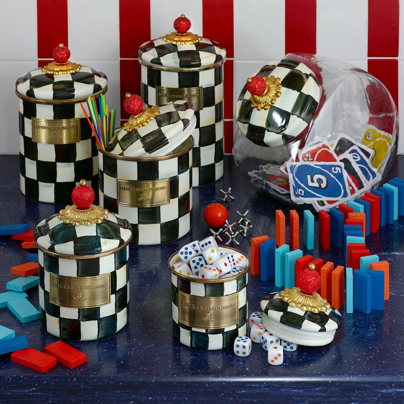 MacKenzie Childs | Courtly Check Small Canister, part of a whimsical set, used creatively to store game pieces and bar accessories on a decorative countertop.