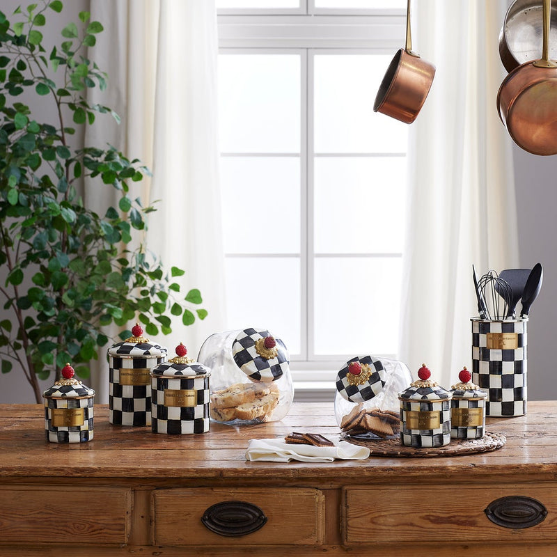 MacKenzie Childs | Courtly Check Small Canister among checkerboard jars on a rustic kitchen countertop, perfect for storing kitchen essentials or decorative use.