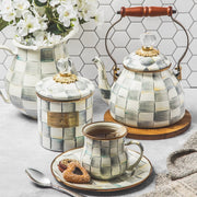 MacKenzie Childs | Sterling Check Small Canister displayed with matching teapot, cup, and pitcher, showcasing its elegant design and versatile use in a chic kitchen setting.