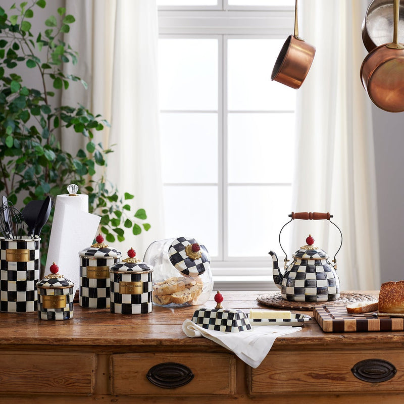 MacKenzie Childs | Cookie Jar with Courtly Check Lid sits amidst a stylish kitchen scene, displaying its checker-patterned lid beside cookies in a glass body.