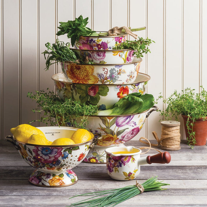 MacKenzie-Childs White Flower Market Large Colander holding lemons, part of a floral-patterned ceramic kitchenware set with fresh herbs, evoking rustic, garden-inspired charm.