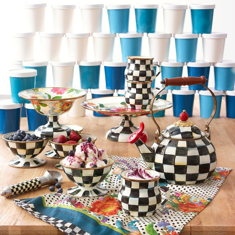 MacKenzie-Childs Courtly Check Ice Cream Dish in whimsical checkerboard pattern, holds ice cream and berries, accompanied by matching ceramics and branded napkin.