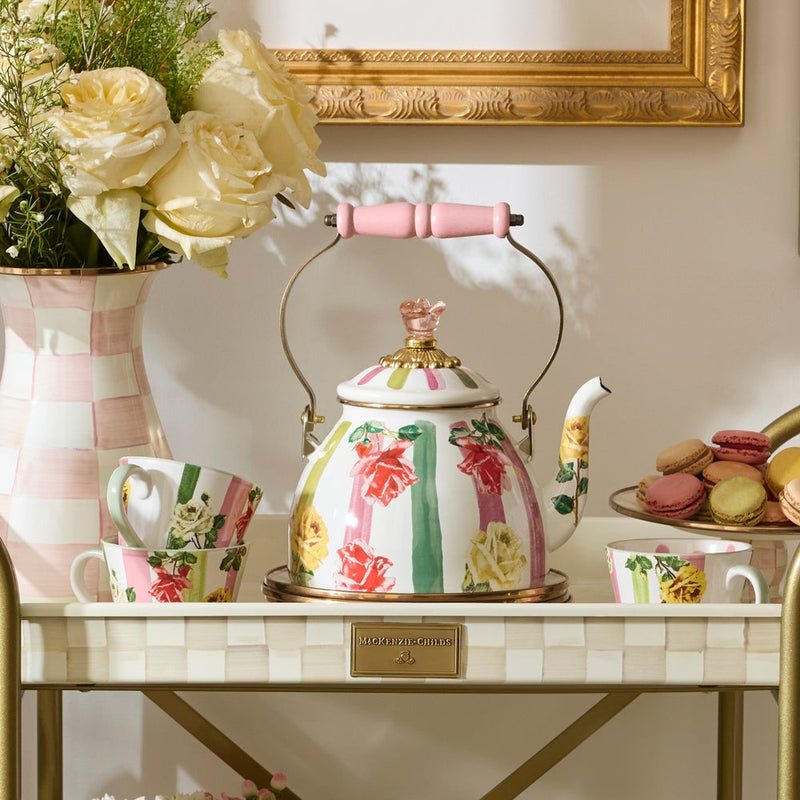 Mackenzie Childs | Garden Gala Tea Kettle, 2 QT. displayed on a cart with matching floral teacups, tiered macarons, and a vase of cream roses.