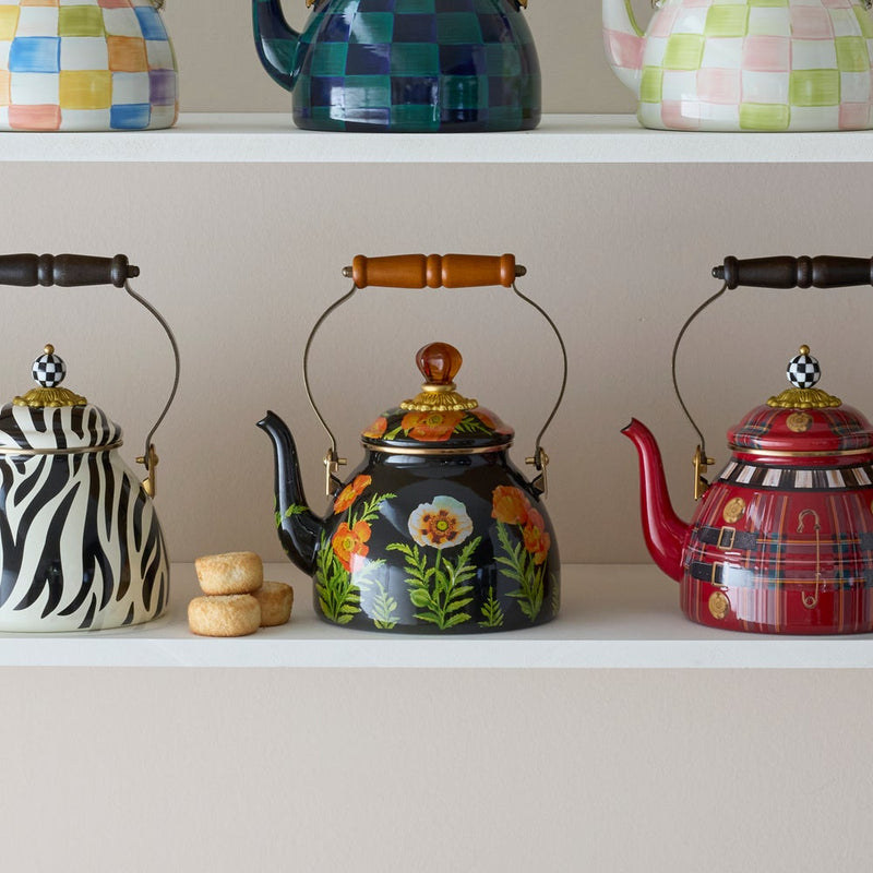 Mackenzie Childs | Poppy Tea Kettle, 2 QT, with hand-painted orange poppy flowers, displayed among decorative kettles on tiered shelves at Athens Cooks.