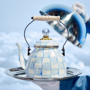 MacKenzie-Childs Sky Check Tea Kettle, 2 Qt, on a silver tray, features hand-painted checks, a wooden handle, and a glass finial lid with brass accents.
