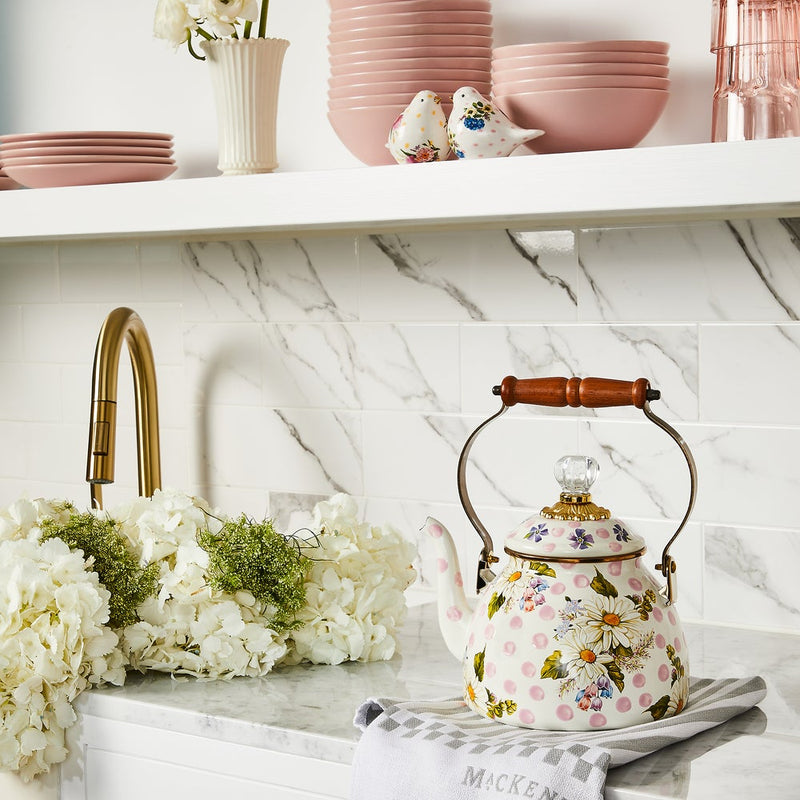 MacKenzie Childs | Wildflowers Pink Tea Kettle, 2 QT., with pink polka dots and daisies, sits on a marble counter, showcasing vintage charm against modern kitchen decor.