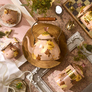 MacKenzie-Childs | Wild Rose Mauve Tea Kettle, 2 Qt, with floral metalware, teacup, and canisters, styled on a wooden board amid vintage accents.