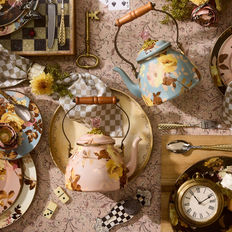 MacKenzie-Childs Wild Rose Mauve Tea Kettle, 2 Qt, with wooden handle and floral design, displayed on a tabletop with matching plates and vintage accents.