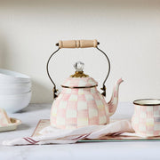 MacKenzie-Childs Rosy Check Tea Kettle, 2 QT, with a wooden handle and glass knob, shown with matching mug on a checkered tray.