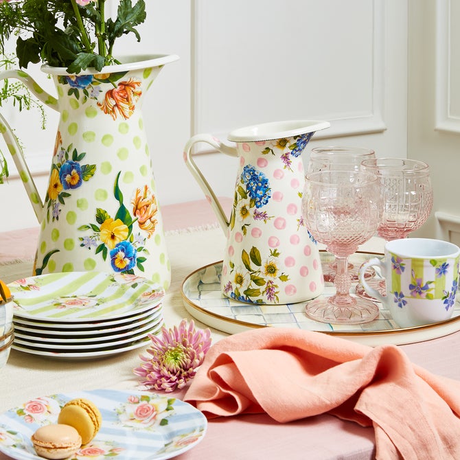 MacKenzie-Childs Sterling Check Round Tray with pink-tinted goblets, floral teacup, and ceramic pitchers, creating a pastel-themed spring tablescape with macarons and fresh flowers.