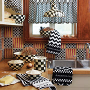 MacKenzie-Childs Courtly Check 7 Cup Measuring Cup on a country-style kitchen counter, surrounded by hand-painted checkerboard bowls and baking essentials, beneath a window.
