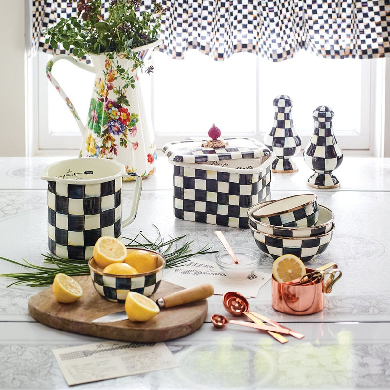 MacKenzie-Childs | Courtly Check 7 Cup Measuring Cup amidst checkerboard ceramics, lemons, herbs, and copper tools, showcasing its hand-painted design and generous capacity.