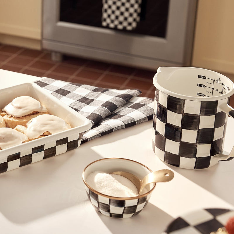 MacKenzie-Childs Courtly Check 7 Cup Measuring Cup on a kitchen counter, surrounded by matching ceramic pieces and baked goods, showcasing its stylish, hand-glazed design.