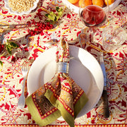 Couleur Nature - Noel Red & Green Tablecloth, 71x71, showcasing festive French linen with holiday patterns, set with elegant dinnerware, holly accents, and seasonal fruits.