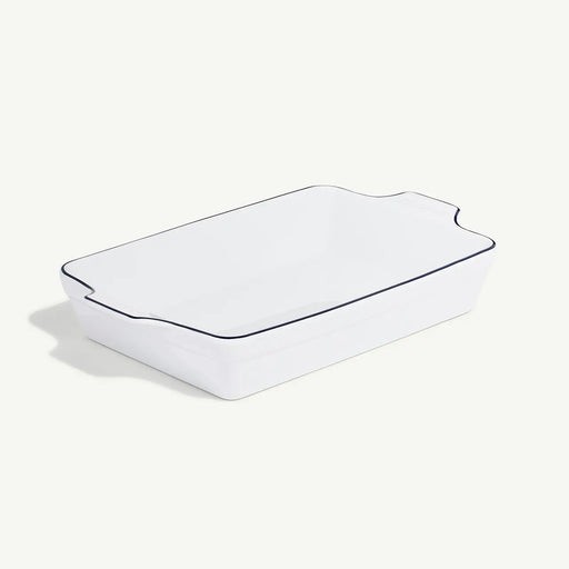 Made In | Rectangular Baking Dish, Navy Rim features a sleek, glossy white finish with flared sides and built-in handles for effortless handling.